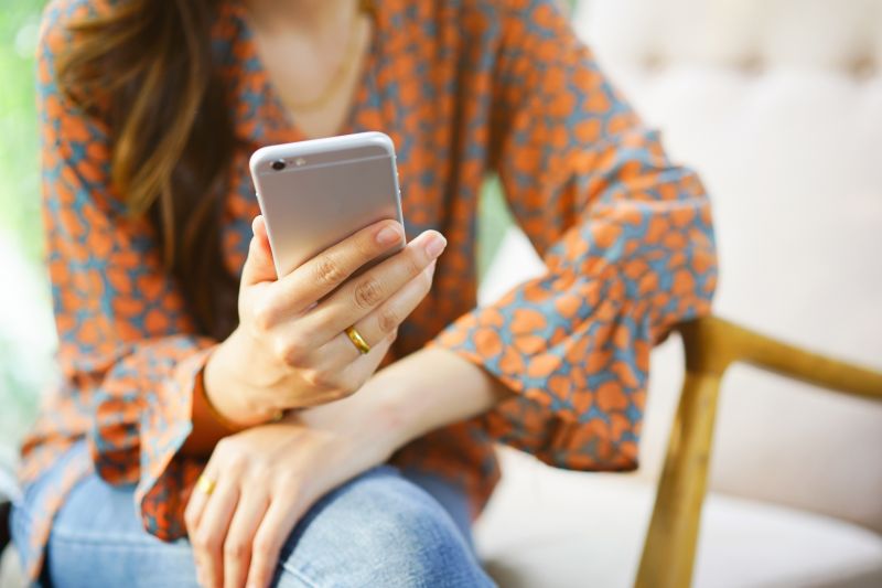 Frau hält Smartphone zur Kontaktaufnahme in den Händen