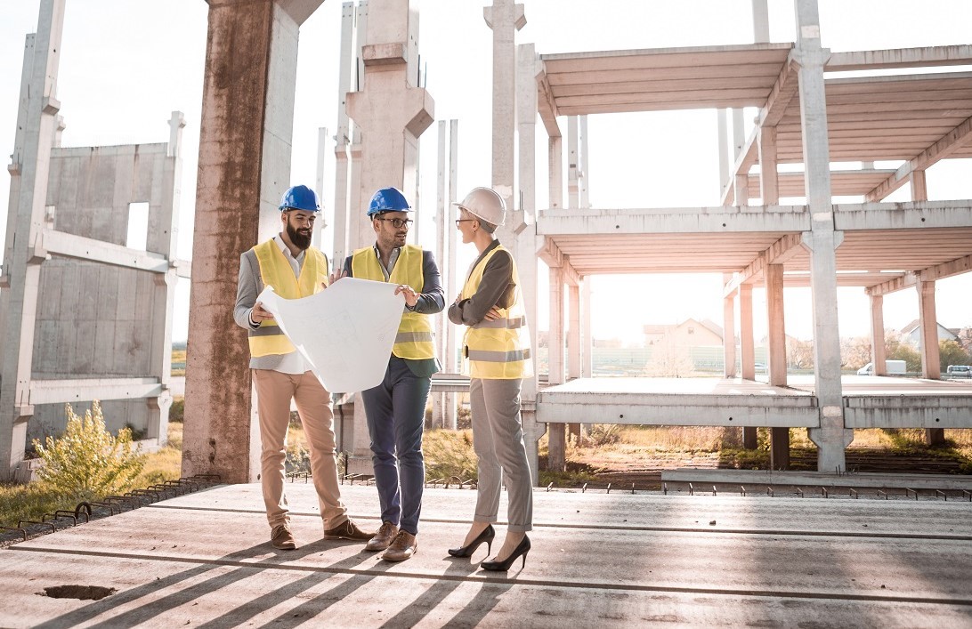 Rechtsanwalt für Baurecht, Besprechung drei Personen auf Baustelle